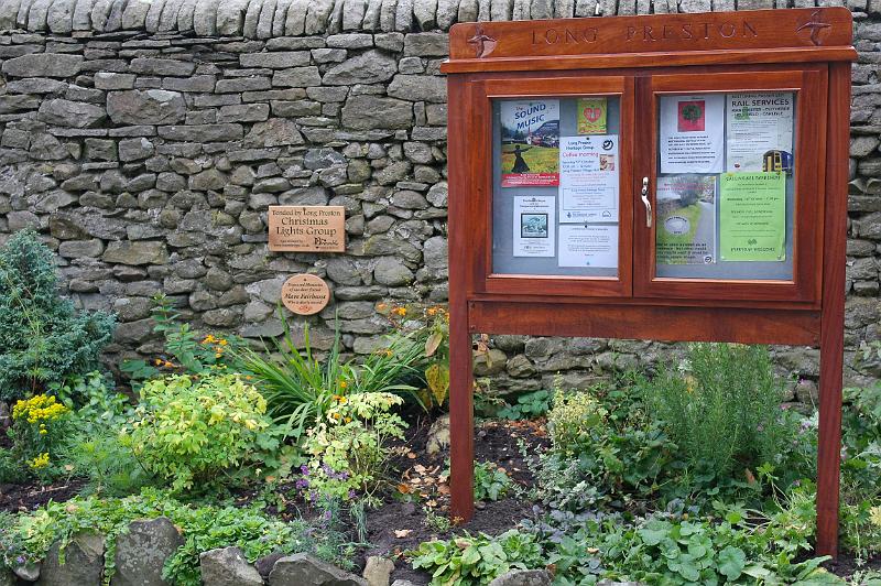 NB22.jpg - Notice board looks good in the setting of the delightful garden planted and maintained by the Chistmas Lights Group.